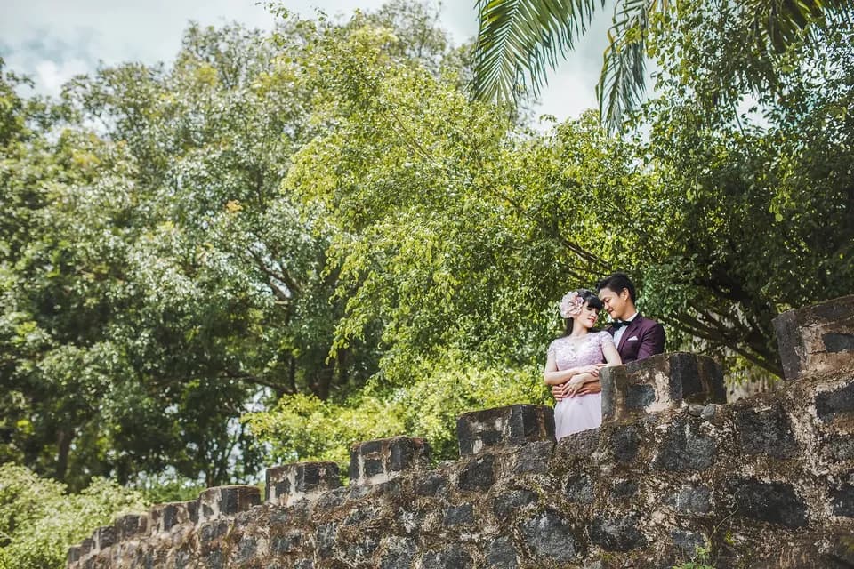 Cặp đôi tựa trên tường thành đá giữa cây xanh
