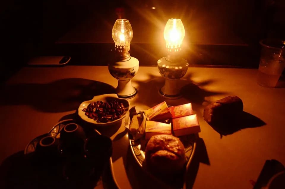 Hai ngọn đèn dầu soi bàn bánh trái và trà