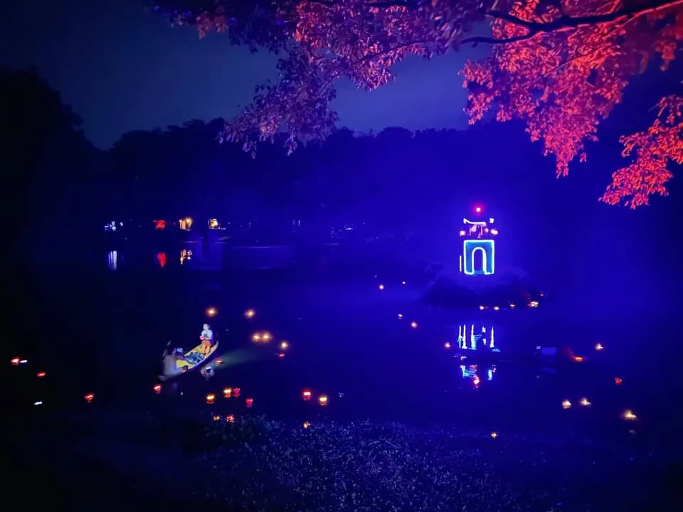 Ngôi miếu giữa hồ rực sáng dưới ánh đèn xanh tím về đêm