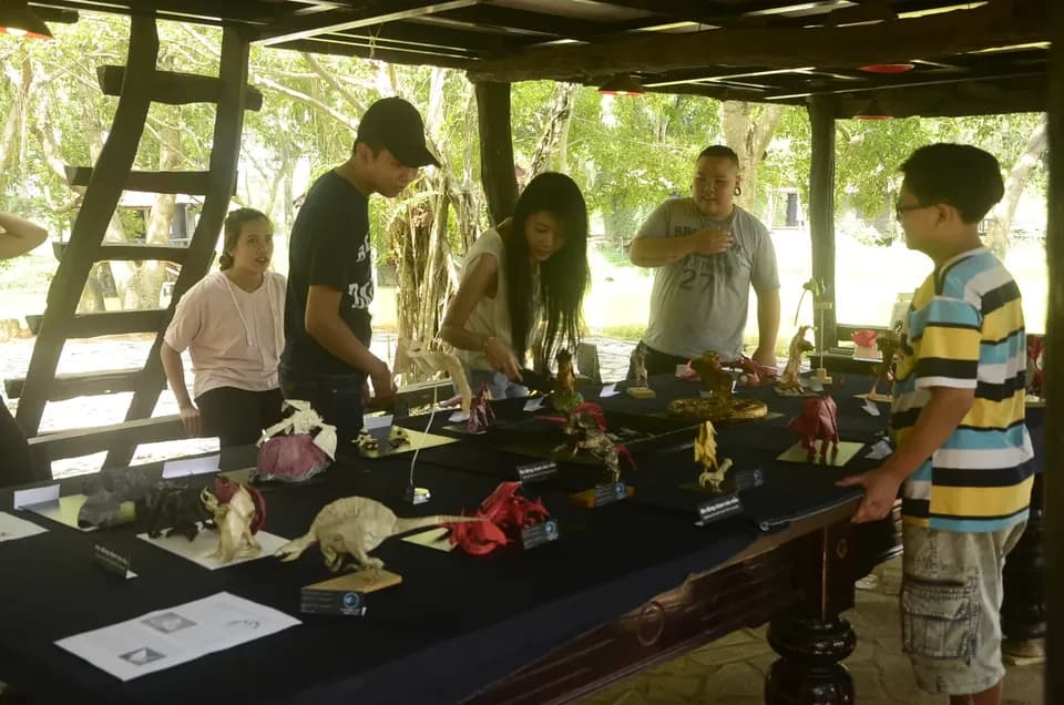 Khách tham quan xem bàn trưng bày origami trong nhà gỗ